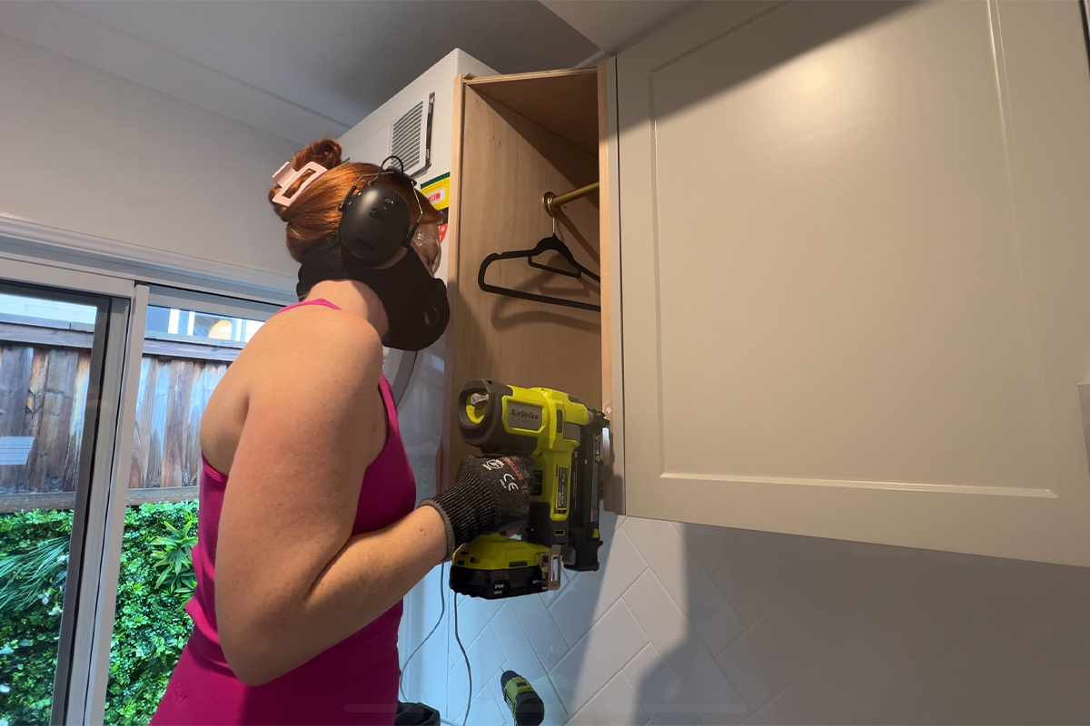 Emma uses the RYOBI Framing Nailer to assemble cabinet storage in laundry