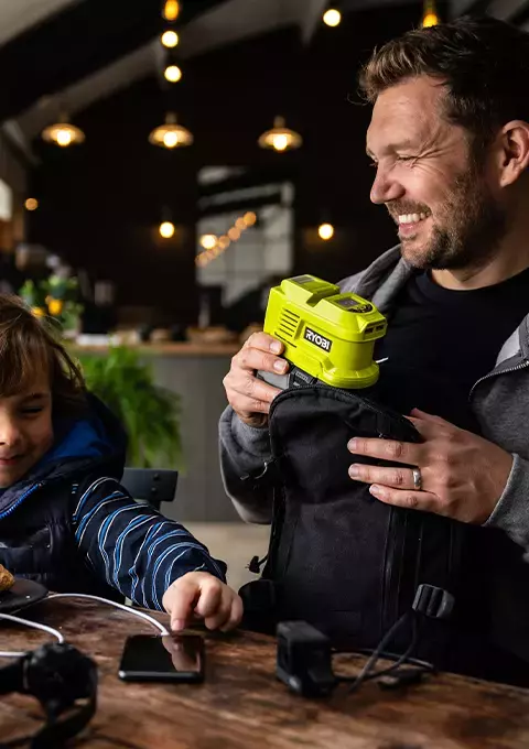 A family having lunch using a RYOBI Battery Topper to charge their devices