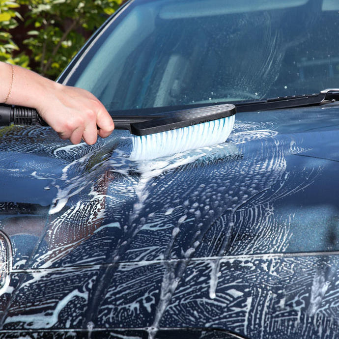 Using a Ryobi pressure washer to scrub down the bonnet of a car